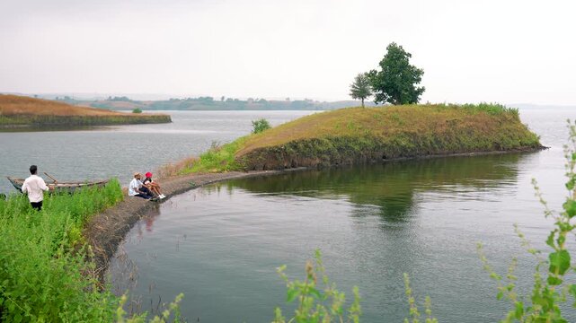 A scenic view of three men boating toward an isolated island, showcasing adventure, exploration, and natural beauty in chacha kota, near Udaipur, Rajasthan, India.