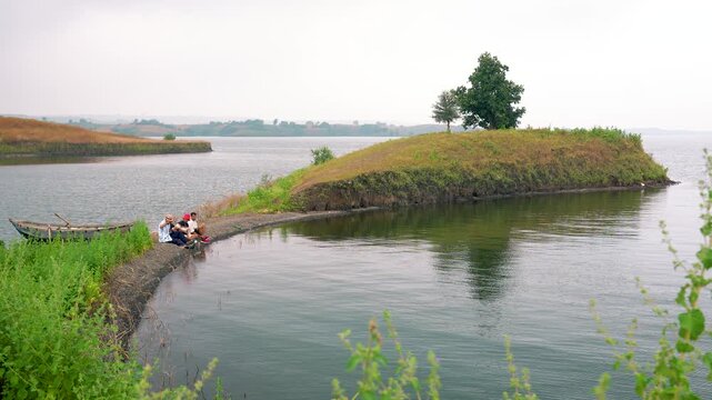 A scenic view of three men boating toward an isolated island, showcasing adventure, exploration, and natural beauty in chacha kota, near Udaipur, Rajasthan, India.