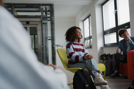Classmates relaxing and talking in high school lounge. - Powered by Adobe