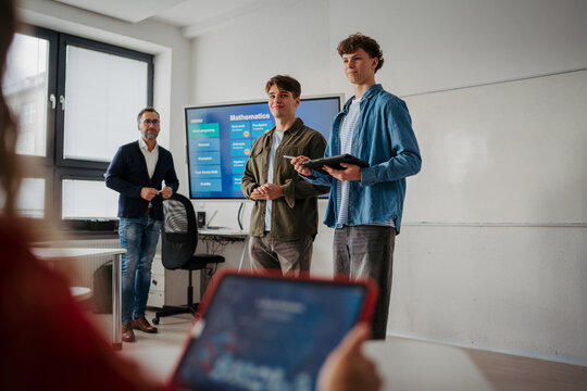 Teen student listening attentively during class with a digital tablet.