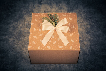 Gift box with christmas tree branch on grunge background.