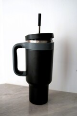 Large travel mug designed for hot and cold beverages with a sleek black finish and a sturdy handle for easy grip