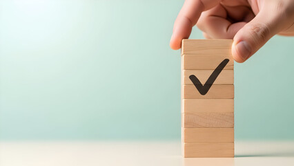 Hand placing wooden block with check mark symbol on stacked blocks