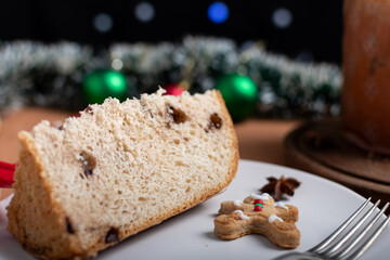 Slice of panettone with chocolate chips and gingerbread cookie.