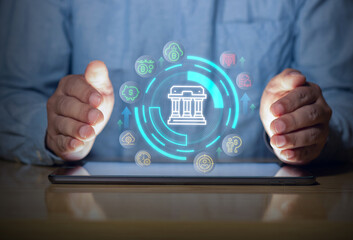 Digital banking protection with secure financial interface on tablet, showing money, savings and fintech icons with hands guarding the system.