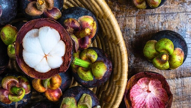 Freshly cut mangosteen fruit in a woven basket