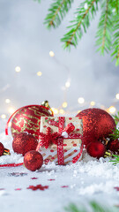 Merry Christmas and Happy Holidays greeting card, frame, banner. New Year. Red Christmas decorations, gift box, present on snow bokeh background. Vertical