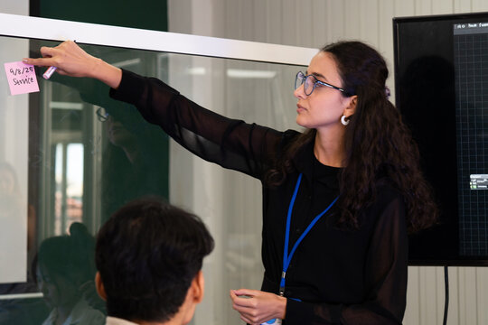 Business team analyzing data on laptops with growth chart in background. Diverse professionals collaborating in office, discussing financial performance, strategy, and success analytics in  workplace.