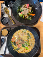 
The closed up of Thai noodles. Asian noodle soup with beef meatball with fresh vegetable on wood table. 