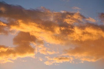 Sunbeams break dramatically through dense clouds in the orange sky.