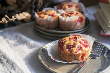 Homemade strawberry white chocolate muffins on a handmade clay plate.