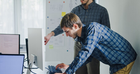 Team adult male engineer collaborate on robotic hand project using AI code solutions machine learning at tech workspace. Artificial intelligence interface, collaboration support prototype development.