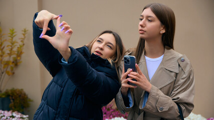 Two women planning creative shot composition outdoors. Concept of teamwork, visual direction, content creation workflow, and collaborative lifestyle project.