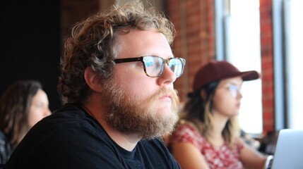 Engaged man with glasses focused on work in a cozy cafe setting