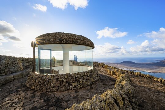 Stairway and viewing platform at the Mirador del R&iacute;o viewpoint, in the evening light with sun stars, designed by artist C&eacute;sar Manrique, view of the island of La Graciosa, Lanzarote, Canary Islands, Spain