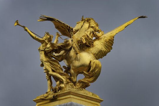 Column with the group of figures Fama of War on the Pont Alexandre III bridge over the Seine, Paris, France
