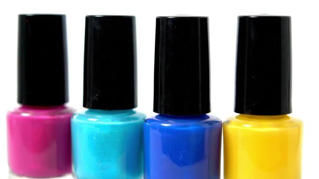 Vibrant colorful nail polish bottles, four in a row, beauty products