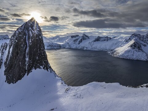 Aerial view of Bergen by the sea, fjord, sunbeams, winter, snow, Mount Segla, Senja, Troms, Norway