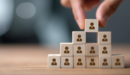 A creative representation of teamwork using wooden blocks with human figures to symbolize collaboration and leadership in a corporate setting.
