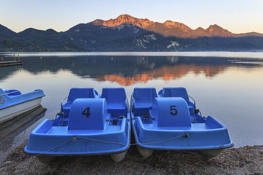 Mountains reflected in lake, pedal boats, morning light, summer, silence, Lake Kochel, Alpine foothills, Bavaria, Germany