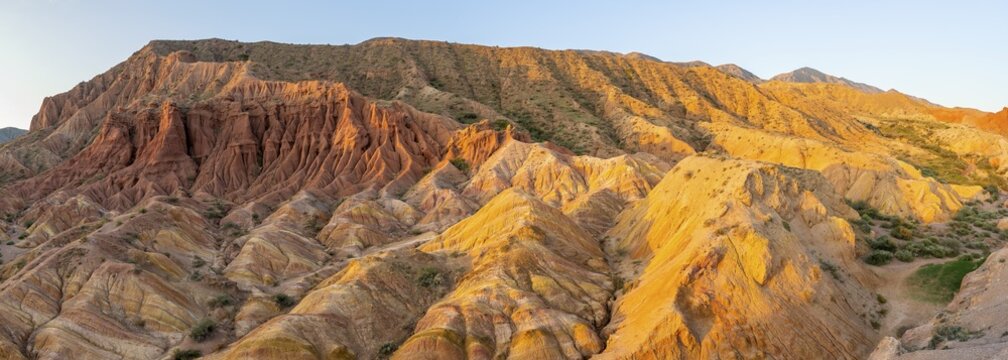 Erosion landscape of red and grey sandstone, rock formations at sunrise with sun star, Skazka Canyon Fairytale gorge, Tosor, Kyrgyzstan