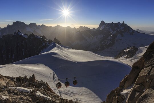 Mountain railway in front of glacier and mountains, sunbeams, backlight, Aiguille du Midi, Mont Blanc massif, French Alps, Chamonix, France