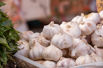 Ripe white garlic whole in a dry peel. Spicy spice fresh garlic background, healthy vegetable garlic top view. A large pile of garlic on a box in a supermarket
