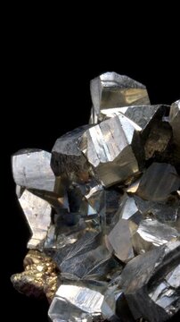 Iron Pyrite (iron sulphide: FeS2) or 'Fool's Gold' (from Bulgaria) with quartz and chalcopyrite crystals, rotating slowly against a black background. Vertical.