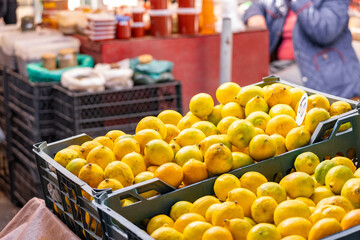 Colorful Display Of Lemons at fruit and vegetables street Market, organic ecological food from local producers. Ripe Yellow Lemons Close-up Background Or Texture. Lemon Harvest, Many Yellow Lemons.
