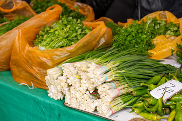 Fresh green onions on a market stand. A bunch of organic green onions. Fresh salad greens on a farmer's market stand.