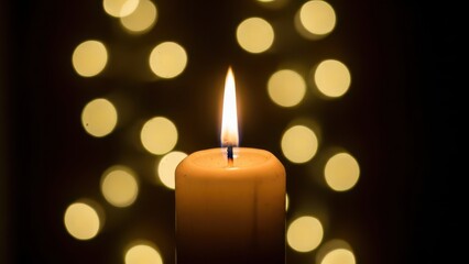 ボケ味のある背景にキャンドル。メリークリスマスのお祝いカード