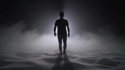 A lone silhouette walks slowly from dense white fog as backlight shapes mysterious scene