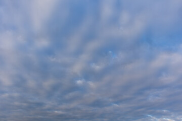 Soft blue sky with layered cloud cover