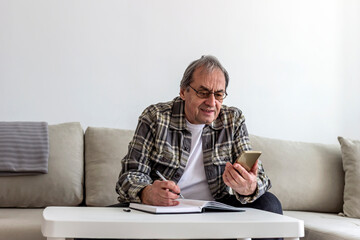 Smartphone, budget planning and senior man in living room for retirement research, website...