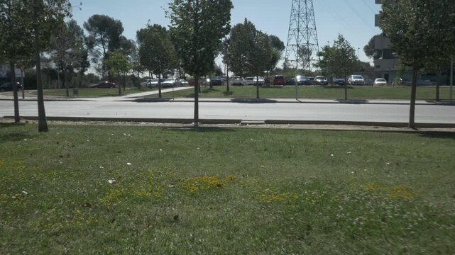 Street gravel pavement gimbal stabilized up grass trees cars traveling road