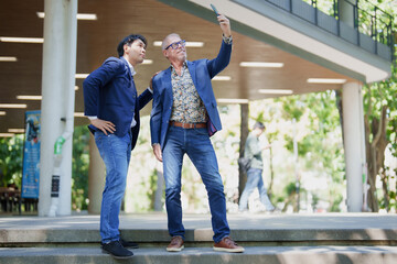 Diverse business professionals taking outdoor selfie with smartphone