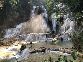 A stunning waterfall surrounded by lush greenery in a tranquil natural setting.