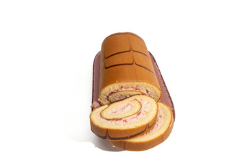 Swiss roll on a platter with two slices in front, isolated on white. Strawberry cream spiral filling and chocolate striped sponge, studio food photo.