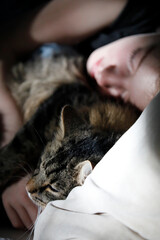 Young woman with pet cat, hugging, cuddling in bed, closeness, love and comfort, close-up.