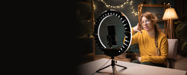 Female blogger recording video using smartphone making live selfie, social media content live video...