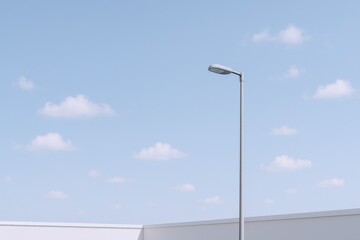 Minimalist street lamp against a serene blue sky with soft clouds creating a clean, contemporary aesthetic