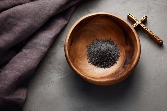 Wooden bowl with ashes and cross on gray surface for ash wednesday observance