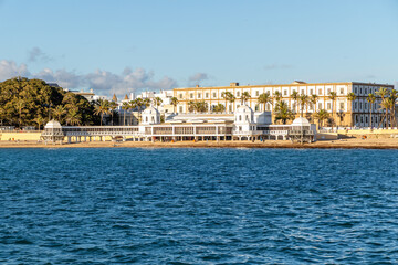 Cadiz, Spain - April 16, 2025: La Caleta beach in Cadiz, with tourists swimming in the sea during the Easter holidays in Cadiz, Spain.