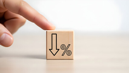 Finger pointing to wooden block with down arrow and percentage symbol