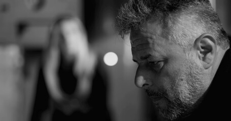 Male employee under intense pressure with head in hand while female boss yells in background,...