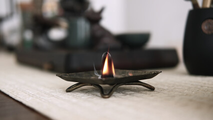 Aroma meditation. Incense burner. Religious tradition fire yoga tools with smoke smoldering on defocused calming background.