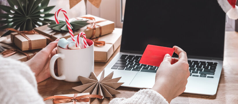 Online Christmas shopping with credit card and laptop, gift boxes and candy cane mug on desk — holiday sale and discounts, e-commerce banner with copy space for promo, Cyber Monday and Black Friday