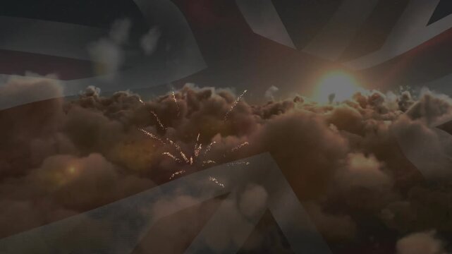 Sparks appearing above cloud bank, fireworks joining, bursting over faint UK flag, honoring UK