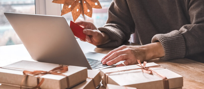 Online Christmas shopping with credit card and laptop, gift boxes and candy cane mug on desk — holiday sale and discounts, e-commerce banner with copy space for promo, Cyber Monday and Black Friday - Powered by Adobe