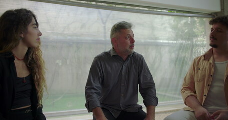 Male participant opening up in front of therapy group, expressing deep emotion while others listen...